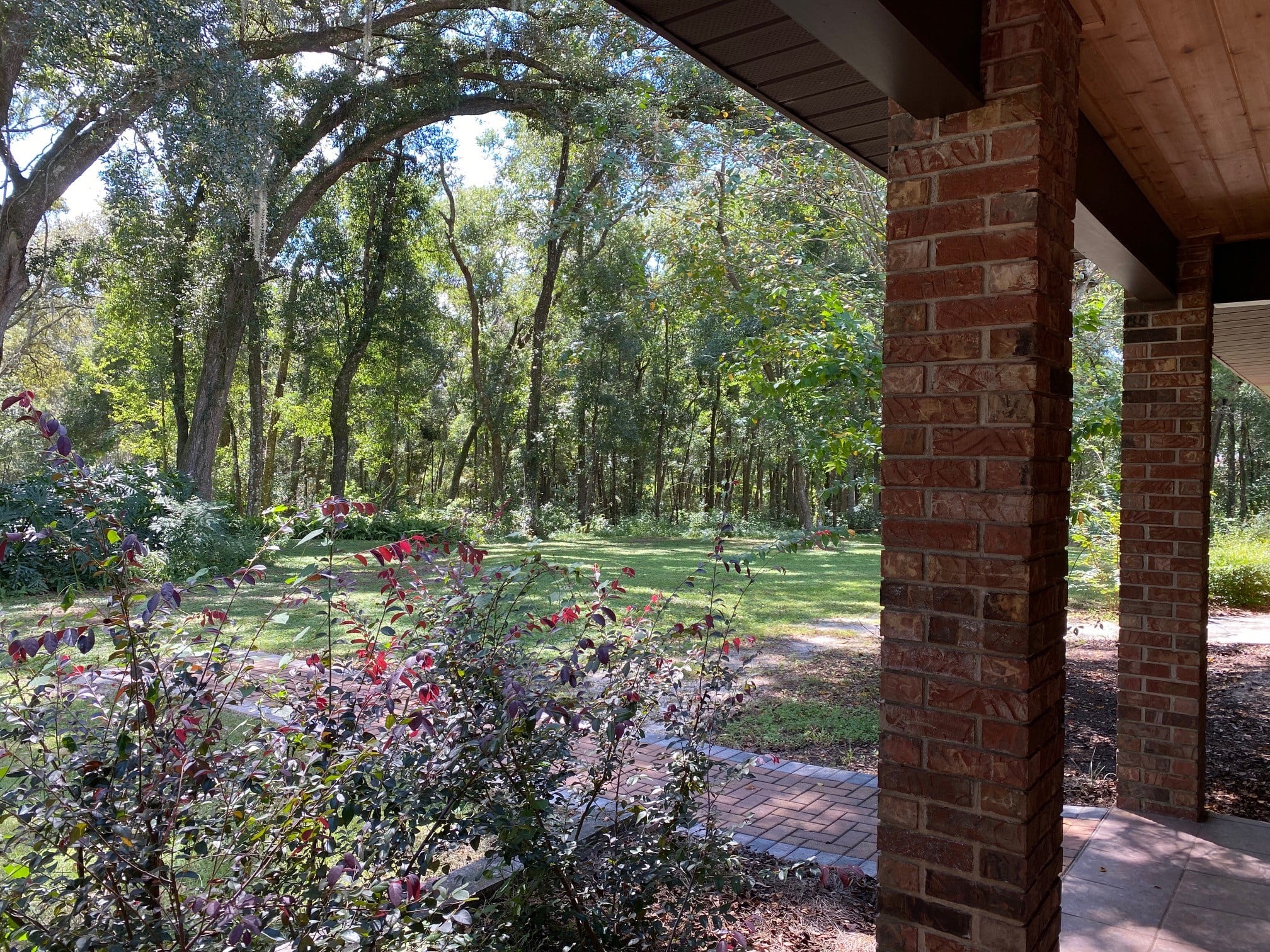 View from front porch. Beautiful custom brick home. Notice wood plank ceilings front, back and covered walkway to guest apartment